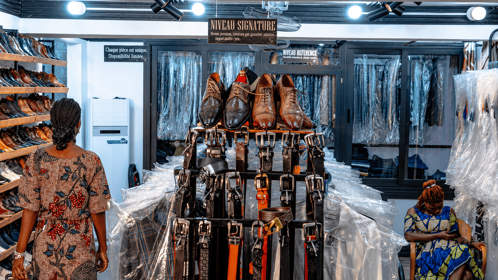 Vue intérieure de la boutique avec chaussures, ceintures et vêtements.